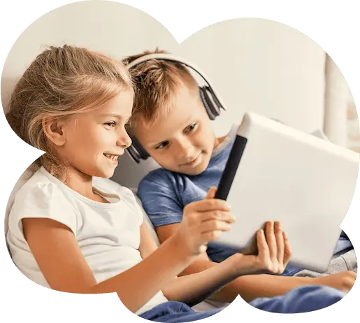 Ein Mädchen und ein Junge schauen lächelnd auf ein Tablet